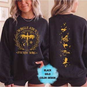 May include: Black sweatshirt with gold graphic design. The front features text that reads "WINGLEADER" and "FOURTH WING" with a dragon illustration. The back has a vertical design of gold dragons and stars. The color design is black and gold.