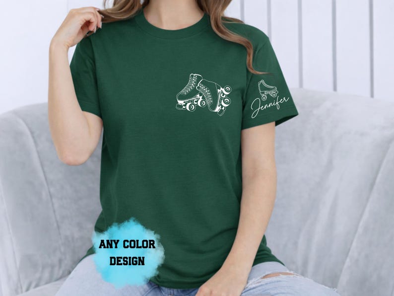 May include: Dark green t-shirt featuring a white roller skate design on the chest and a smaller skate with the name "Jennifer" on the sleeve. The shirt also has the text "ANY COLOR DESIGN" in a blue bubble.