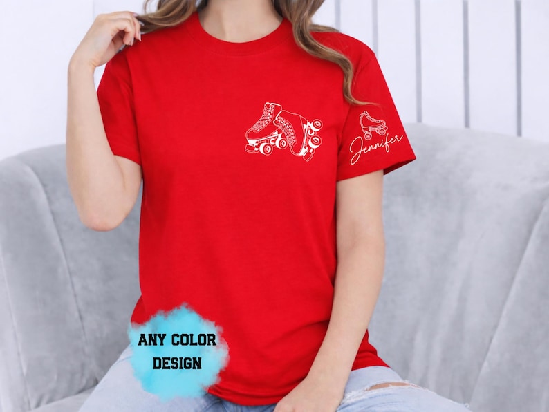 May include: Red t-shirt with a white roller skate graphic on the chest and a smaller skate with the name "Jennifer" on the sleeve. The shirt also has the text "ANY COLOR DESIGN" in a blue cloud.
