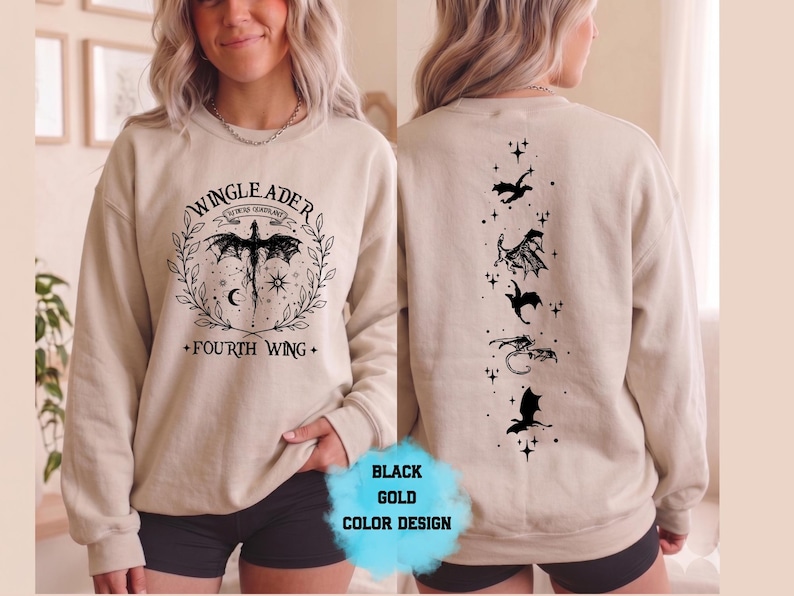 May include: Beige sweatshirt with black dragon graphic and text "WINGLEADER" and "FOURTH WING". The back features a vertical line of black dragon silhouettes and stars. A "BLACK GOLD COLOR DESIGN" label is visible.