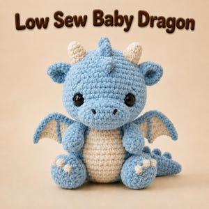 May include: A light blue and cream crochet baby dragon plush toy with large black eyes, small horns, wings, and a textured yarn finish. The text "Low Sew Baby Dragon" is displayed in brown letters above the creature on a light tan background.