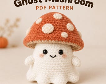 May include: A crochet ghost mushroom figure with a rust-coloured cap featuring white spots and a white body. The figure has black bead eyes, a stitched smile, and pink cheeks. The text "Ghost Mushroom PDF PATTERN" is displayed above the figure.