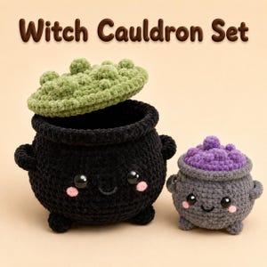 Puede incluir: Un conjunto de calderos de ganchillo Witch Cauldron Set que incluye un caldero negro grande con tapa verde texturizada y uno gris más pequeño con tapa morada. Ambos tienen ojos negros, sonrisas bordadas y mejillas rosadas en sus cuerpos.