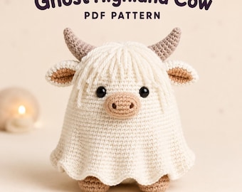 Op de afbeelding: Een gehaakt Highland-rundfiguur gehuld in een wit spookkostuum met een uitlopende zoom, voorzien van beige hoorns, een beige snuit en zwarte ogen. De tekst Ghost Highland Cow PDF PATTERN staat in donkerpaars boven het gehaakte figuur.