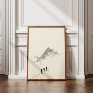 May include: A framed art print showing a minimalist mountain scene in grey and black. Three figures are silhouetted, walking a path towards the mountain. The frame is made of wood.