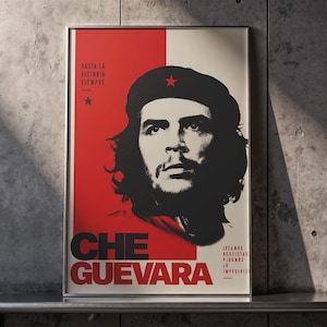 May include: A rectangular framed poster featuring a high-contrast black and white portrait of Che Guevara wearing a beret with a red star. The background is split between red and off-white, with the text "HASTA LA VICTORIA SIEMPRE" and "CHE GUEVARA".