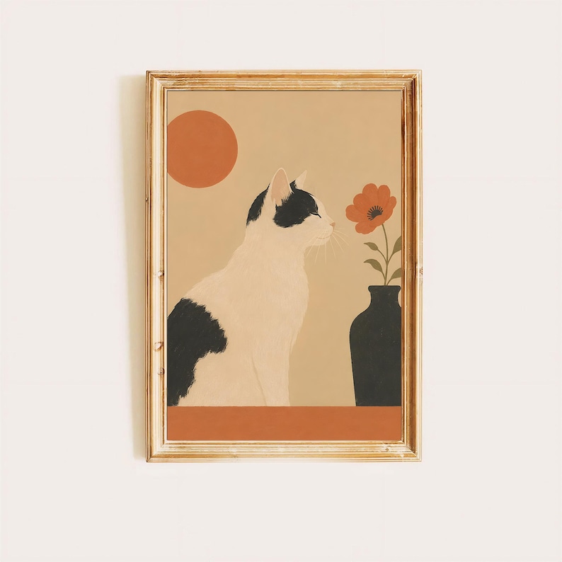 以下が含まれることがあります： 黒と白の猫が横向きに座り、オレンジ色の花が一輪入った黒い花瓶の横にいる様子を描いた額入りアートプリント。背景は無地のベージュ色で、左上隅には太陽を表す大きなオレンジ色の円が描かれています。