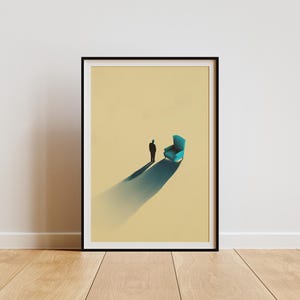 May include: A framed art print featuring a minimalist illustration on a light tan background. The image depicts a small, dark silhouette of a person standing next to a bright teal armchair, with a long, dramatic shadow cast across the floor.
