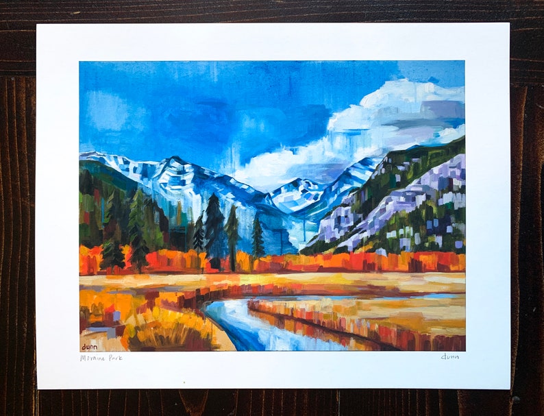 May include: A painting of a mountain landscape with a river flowing through a field of yellow grass. The mountains are snow-capped and the sky is blue with white clouds. The painting is signed "Dunn" in the bottom right corner and "Montana Park" in the bottom left corner.