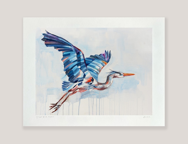 May include: A watercolor painting of a great blue heron in flight. The bird is painted in shades of blue, purple, and orange, with a white background. The painting is signed "Jenna" in the bottom right corner.