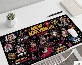 May include: A rectangular black desk mat featuring a colorful graphic print with the text NEW ACHIEVEMENT, DESPRADO, PRINCESS POSSE, THIS IS AN OUTRAGE, I AM YELLING, CARL, DUNGEON CRAWLER, and various illustrations of cats, a dinosaur, and potions.