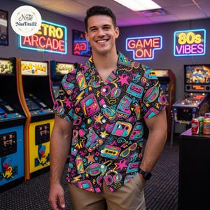May include: A short-sleeve button-down shirt featuring a vibrant, multi-colored pattern of 1980s-themed icons including cassette tapes, roller skates, handheld gaming consoles, headphones, and lightning bolts against a black background.