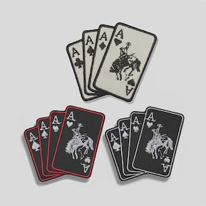 May include: Three sets of Ace of Spades playing card patches. One set is white with black trim, another is black with red trim, and the last is black with white trim. Each patch features a cowboy riding a bucking bronco.