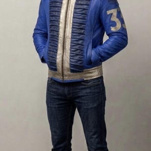 May include: A blue and metallic gold leather jacket featuring a stand-up collar with the number 33, vertical pleated panels on the chest, and the number 33 on the left sleeve. The text TANZIE LEATHER is visible in the upper left corner of the image.
