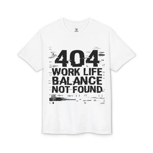 Op de afbeelding: Wit t-shirt met een zwart grafisch ontwerp. Het ontwerp toont het nummer "404" boven de tekst "WORK LIFE BALANCE NOT FOUND" in een glitch-stijl lettertype. Het t-shirt heeft korte mouwen en een ronde hals.