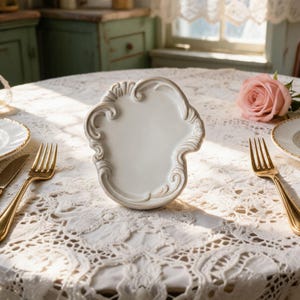 Baroque ceramic trinket dish with soft ivory glaze and curved edges