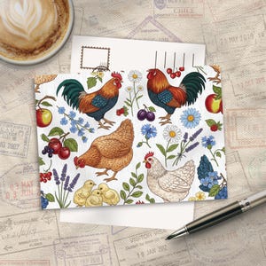 Op de afbeelding: Een rechthoekige ansichtkaart met een herhalend patroon van hanen, hennen en kuikens, afgewisseld met illustraties van madeliefjes, lavendel, korenbloemen, kersen, pruimen en appels op een witte achtergrond met een subtiele houtnerftextuur.