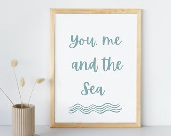 May include: A framed print with the text "You. Me and the Sea" in light blue cursive font. The print features a stylized wave design in light blue below the text. The frame is made of natural wood.