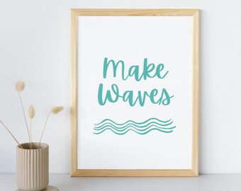 May include: A framed print with a light wood frame and a white background. The print features the text "Make Waves" in teal blue lettering with a stylized teal blue wave design below the text.