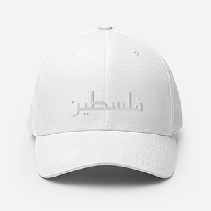 Peut inclure: Casquette de baseball blanche avec une visière incurvée. La casquette présente une inscription arabe brodée sur le devant. Le chapeau est de conception classique à six panneaux avec un bouton sur le dessus et une sangle réglable.