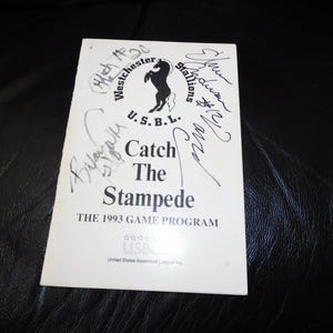 May include: A white game program for the Westchester Stallions, featuring a black horse logo and the text "Catch The Stampede." The program is from the 1993 season and includes player signatures.
