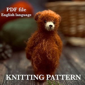 Può includere: Un piccolo orsacchiotto marrone fatto a mano, con muso bianco e occhi scuri. L'orso è il punto focale, su uno sfondo sfocato. Il testo in alto recita "PDF file English language" e in basso "KNITTING PATTERN".