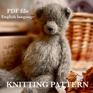 May include: A gray knitted teddy bear with a soft, textured appearance. The bear is sitting, with the words "PDF file English language" and "KNITTING PATTERN" in white text. The background includes a basket and dried flowers.