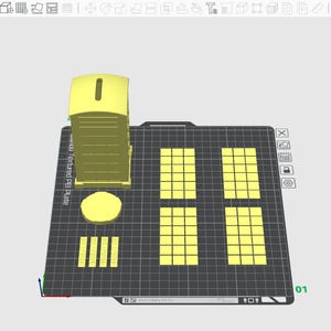 May include: A yellow 3D-printed model of a portable toilet, a circle, several rectangles, and a grid of squares. The objects are arranged on a black surface with a grid pattern. The model is likely for a construction or architectural project.