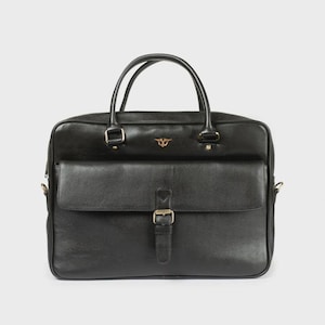 May include: Black leather briefcase with a front flap pocket secured by a buckle. The bag has two top handles and a small gold emblem. The hardware is gold-toned. The bag is designed for carrying documents and other essentials.