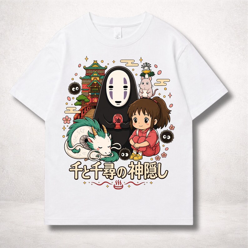 Op de afbeelding: Wit t-shirt met een kleurrijke afbeelding uit de animatiefilm Spirited Away. Het ontwerp toont personages als No-Face, Chihiro en Haku, samen met Japanse tekst. Het kunstwerk is omgeven door decoratieve elementen.