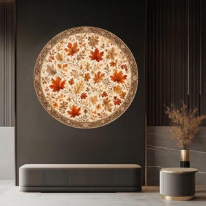 May include: A large circular wall art piece featuring a detailed pattern of autumn maple leaves in shades of red, orange, and brown against a cream background, enclosed within a decorative dark brown border with intricate geometric patterns.