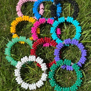 May include: A collection of ten circular bracelets featuring a textured, spiky, geometric design. The bracelets are available in a variety of solid colours including pink, blue, black, yellow, magenta, turquoise, red, purple, white, and green.