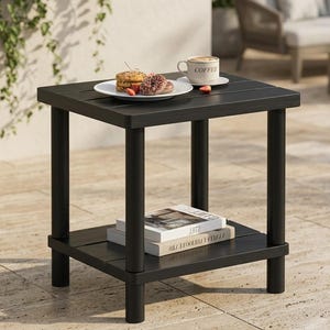 May include: A square black side table with four cylindrical legs and a lower shelf. The top surface holds a white plate with two pastries and a white mug with the word COFFEE printed on it. Two books are stacked on the lower shelf.
