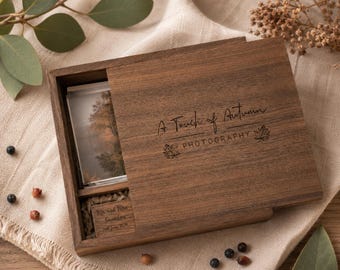 Könnte beinhalten: Eine rechteckige, dunkelbraune Holzschachtel mit Schiebedeckel, graviert mit dem Text A Touch of Autumn PHOTOGRAPHY und zwei Blattsymbolen. Im Inneren befinden sich ein kleines Foto und ein Holzblock mit der Gravur Mr and Mrs Saunders 2nd June 2024.
