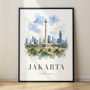 Op de afbeelding: Een ingelijste kunstdruk met een aquarelillustratie van de skyline van Jakarta, gecentreerd op het Nationaal Monument, met groene bomen op de voorgrond en een blauwe lucht. De tekst JAKARTA Indonesia staat onderaan in het zwart gedrukt.