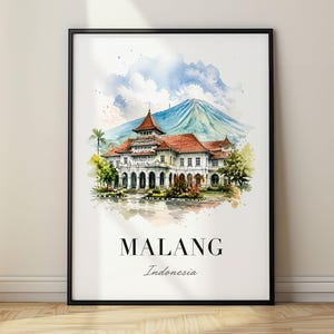 Pode incluir: Uma impressão de arte em aquarela emoldurada apresentando o edifício Tugu Malang com telhado vermelho e fachada branca, contra um fundo de montanha azul. O texto MALANG Indonesia está impresso em preto na parte inferior do papel branco.