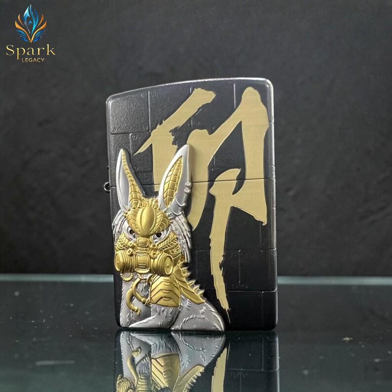 May include: Black and gold metal lighter with a detailed rabbit design on the front. The rabbit has a gas mask and armor. Gold Japanese characters are on the right side of the lighter. The brand "Spark Legacy" is in the upper left corner.