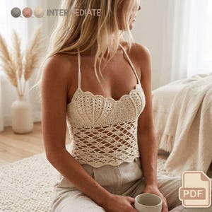 Könnte beinhalten: Cremefarbenes Häkeltop mit Neckholder und gewellten Kanten. Das Top hat ein rautenförmiges Lochmuster. Das Wort "INTERMEDIATE" ist in der oberen linken Ecke sichtbar. Ein PDF-Symbol befindet sich in der unteren rechten Ecke.