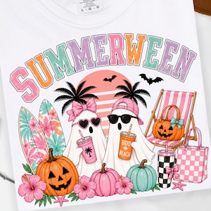 May include: A white t-shirt featuring a graphic with the text SUMMERWEEN in pastel colors. The design includes two ghosts, one wearing a pink bow and heart sunglasses, the other a pink cap and black sunglasses, with surfboards, pumpkins, and beach gear.