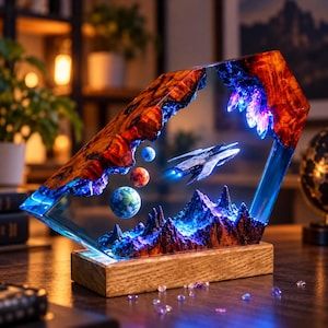 May include: A hexagonal resin lamp featuring a wooden base, a miniature white spacecraft, three small spherical planets, and a mountain landscape. The structure is illuminated with blue and purple LED lights, showcasing a space-themed diorama.