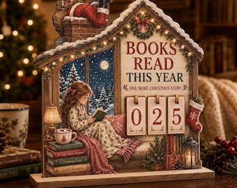 May include: A decorative wooden tabletop sign shaped like a house, featuring a girl reading a book by a window, a Santa figure on the chimney, and a countdown calendar with the text BOOKS READ THIS YEAR ONE MORE CHRISTMAS STORY and the number 025.