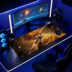 May include: A long rectangular gaming mouse pad featuring a detailed anime illustration of a character with yellow hair and a sword. The pad is on a desk with a curved monitor, mouse, and headphones. The color scheme is primarily yellow, brown, and blue.