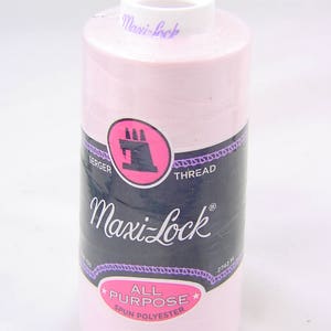 以下が含まれることがあります： オーバーロックミシン用のピンク色のスプール、Maxi-Lock オールパーパス スパンポリエステル糸。スプールには、ブランド名の入った白いラベルと、「オーバーロック糸」と「Maxi-Lock」の文字が入った黒いラベルが付いています。