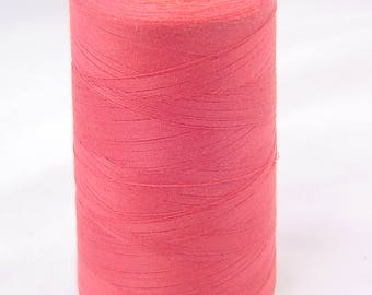 May include: A spool of bright pink thread with a yellow plastic top.