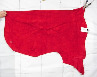 May include: A large, bright red piece of suede leather. The leather is laid flat on a white surface.