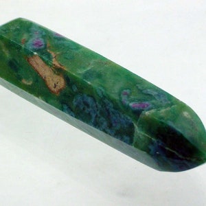 May include: A green, blue, and pink gemstone point, also known as a crystal, with a faceted shape.