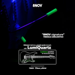 Könnte beinhalten: 8NOV Signature Tremoloarm und Schalter aus LumiQuartz-Material. Das Bild zeigt einen Gitarren-Tremoloarm und eine Schalterkappe, die vor einem dunklen Hintergrund hellgrün leuchten. Ein Diagramm zeigt die leuchtende Position an einer Stratocaster-Gitarre.