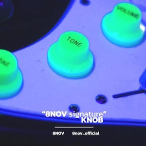 May include: A white electric guitar pickguard featuring three bright green glowing control knobs labeled TONE, VOLUME, and ONE. The text 8NOV signature KNOB and 8NOV 8nov_official is printed in white on the lower section of the guitar component.