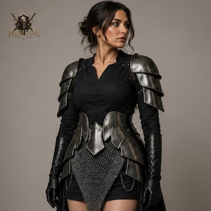 May include: A set of dark metallic armor featuring layered shoulder pauldrons, a waist-cinching plate belt, and a chainmail skirt overlay. The armor is worn over a black long-sleeved shirt and black shorts, paired with long black leather gloves.