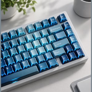 May include: A mechanical computer keyboard with a white frame and a gradient keycap set that transitions from light blue to deep navy blue. The keys feature white lettering, including standard function keys, a backspace key, and an enter key.